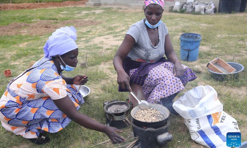 Members of the Women's Farming Syndicate (WFS) roast baobab fruit seeds in Domboshava, Mashonaland East Province, Zimbabwe, on Dec. 21, 2021.(Photo: Xinhua)