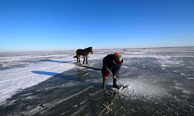 A fisherman prepares to harvest fish on Chagan Lake in Songyuan City, northeast China's Jilin Province, Dec. 26, 2021.(Photo: Xinhua)