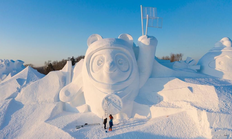 Aerial photo taken on Dec. 27, 2021 shows workers finishing the main snow sculpture featuring Beijing 2022 mascots at the 34th Harbin Sun Island International Snow Sculpture Art Exposition in Harbin, northeast China's Heilongjiang Province. (Xinhua/Xie Jianfei)