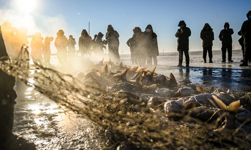 Visitors watch ice-fishing on Chagan Lake in Songyuan City, northeast China's Jilin Province, Dec. 26, 2021.(Photo: Xinhua)