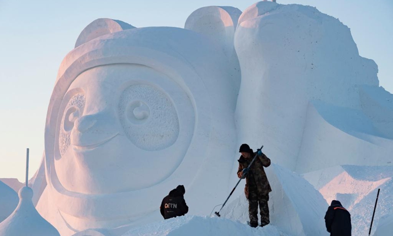 Workers finish the main snow sculpture featuring Beijing 2022 mascots at the 34th Harbin Sun Island International Snow Sculpture Art Exposition in Harbin, northeast China's Heilongjiang Province, Dec. 27, 2021. (Xinhua/Xie Jianfei)