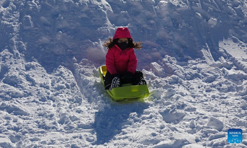 A child enjoys playing on snow in the Kfardebian region of Lebanon on Dec. 26, 2021.(Photo: Xinhua)