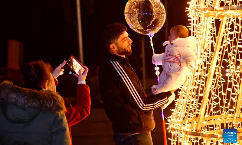 People take photos near a Christmas tree in Damascus, Syria, on Dec 29, 2021.Photo:Xinhua