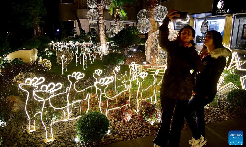 People take photos near a Christmas tree in Damascus, Syria, on Dec 29, 2021.Photo:Xinhua