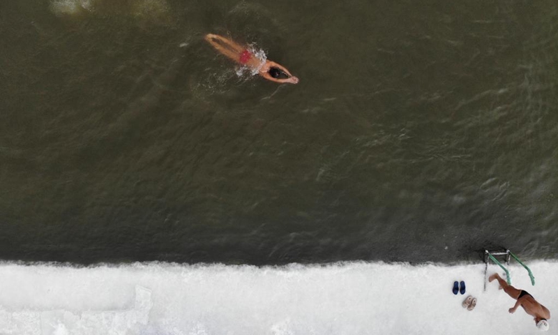 Aerial photo shows a winter swimming enthusiast swimming in the Songhua River in Harbin, northeast China's Heilongjiang Province, Jan. 1, 2022. (Xinhua/Zhang Tao)