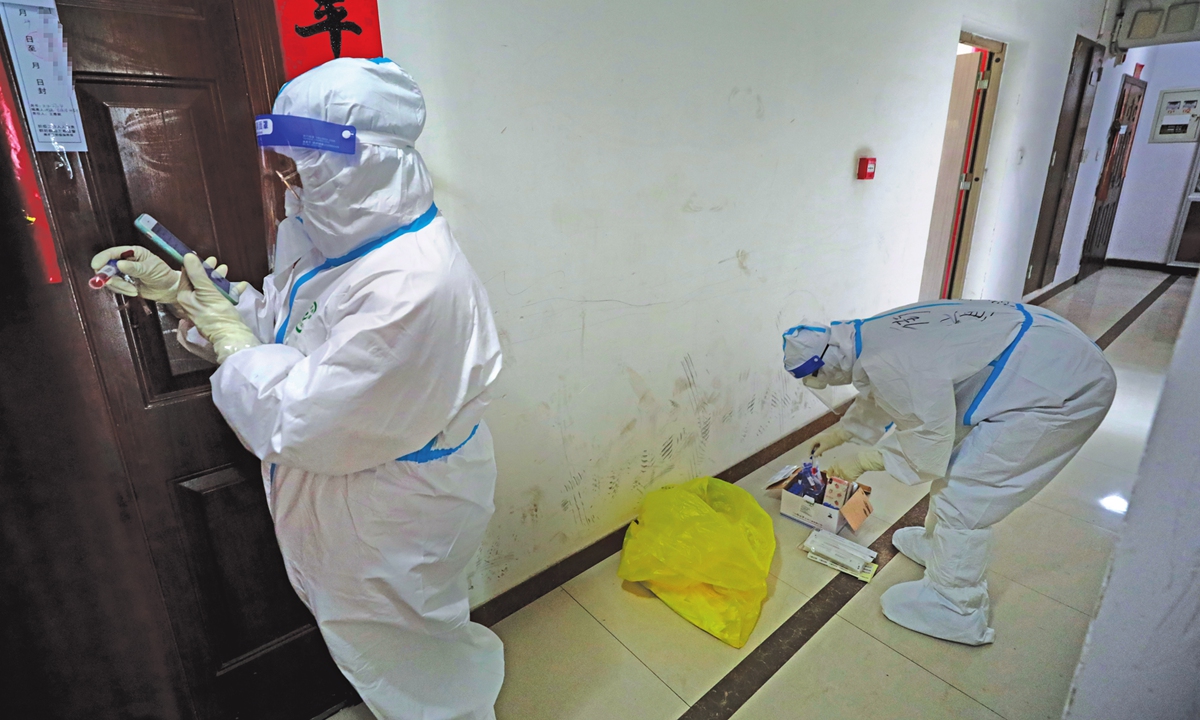 Medical staff conduct nucleic acid tests door to door in a community under lockdown management in Xi'an on January 2, 2022. Photo: IC