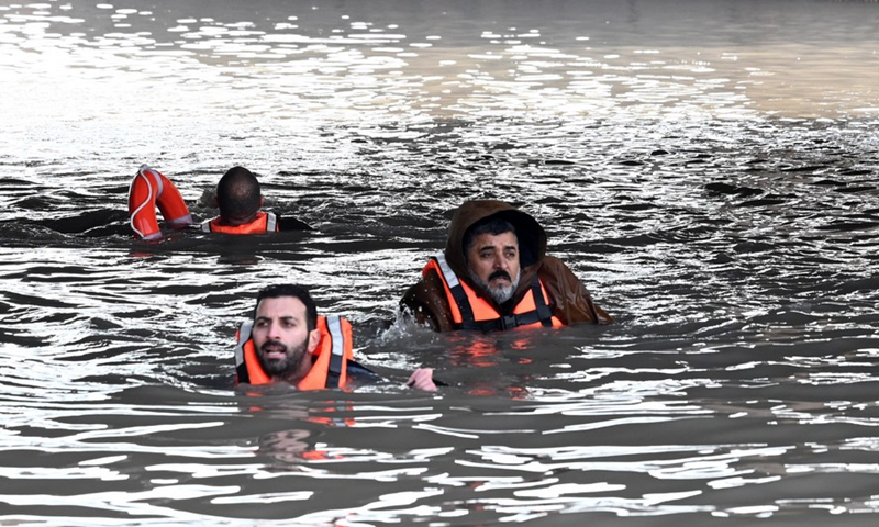 Rescue workers help a man trapped by rainwater at a road tunnel in Farwaniya Governorate, Kuwait, Jan. 2, 2022.Photo:Xinhua