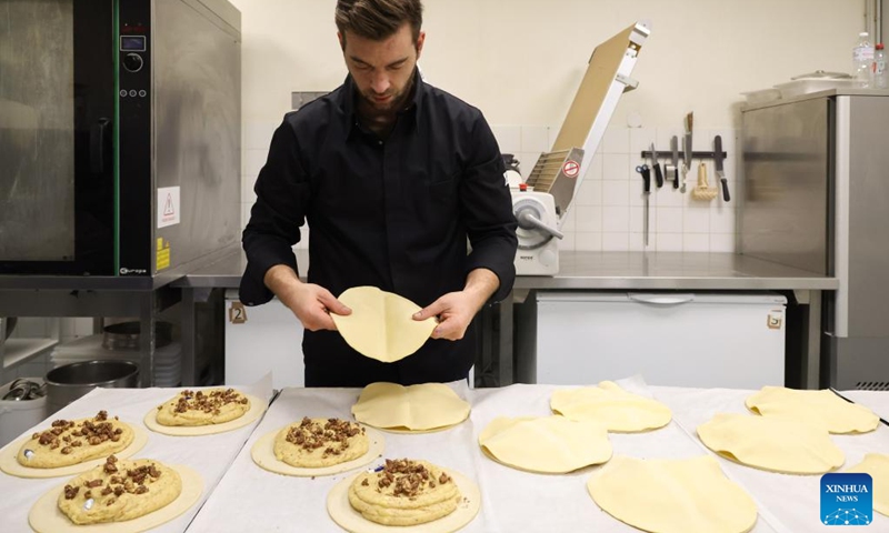 A baker prepares the traditional Epiphany cakes (galette des rois) at a bakery in La Turbie, France, Jan. 5, 2022. Galette des rois, which means the cake of king, is a traditional French dessert.(Photo: Xinhua)