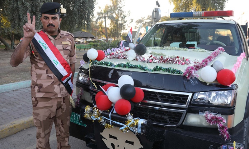 An Iraqi soldier waves the victory sign while standing near a military vehicle decorated with balloons on the occasion of Iraqi Army Day in Baghdad, Iraq, on Jan. 6, 2022.(Photo: Xinhua)