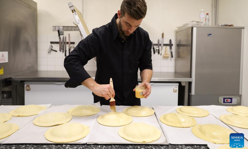 A baker prepares the traditional Epiphany cakes (galette des rois) at a bakery in La Turbie, France, Jan. 5, 2022. Galette des rois, which means the cake of king, is a traditional French dessert.(Photo: Xinhua)