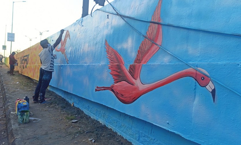 An artist gives a final touch to his flamingo artwork on the wall in Mumbai, India, Jan. 10, 2022.(Photo: Xinhua)