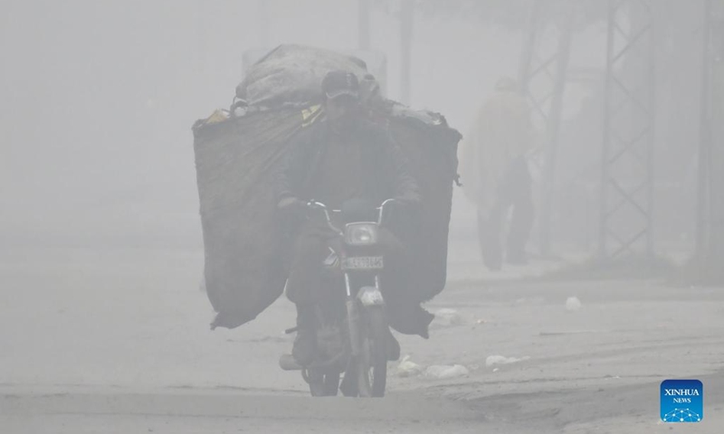 A man rides a motorcycle in dense fog in Lahore, Pakistan, on Jan. 13, 2022.(Photo: Xinhua)