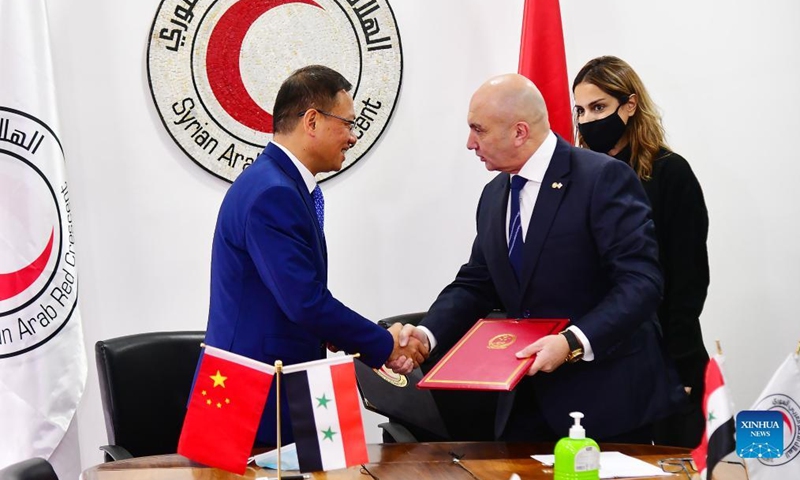 Chinese Ambassador to Syria Feng Biao (L) shakes hands with Khaled Hboubati, the head of the Syrian Arab Red Crescent (SARC), after signing a delivery note for the food aid in Damascus, Syria, on Jan. 16, 2022.Photo:Xinhua