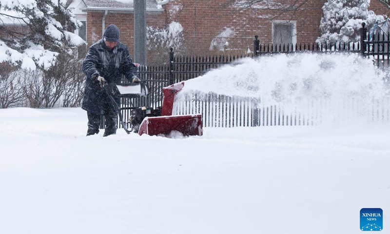 A man uses a snow blower to clear snow during a snowy day in Mississauga, the Greater Toronto Area, Canada, on Jan. 17, 2022. Environment Canada issued a winter storm warning calling for up to 60 cm of snow in some parts of the Greater Toronto Area by Monday night.(Photo: Xinhua)