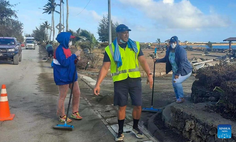 Local residents clear ash and rubbles from a road at Nuku'alofa, capital of Tonga, Jan. 20, 2022. On Friday and Saturday, the Hunga Tonga-Hunga Ha'apai volcano in Tonga erupted violently and triggered tsunami in Tonga.(Photo: Xinhua)