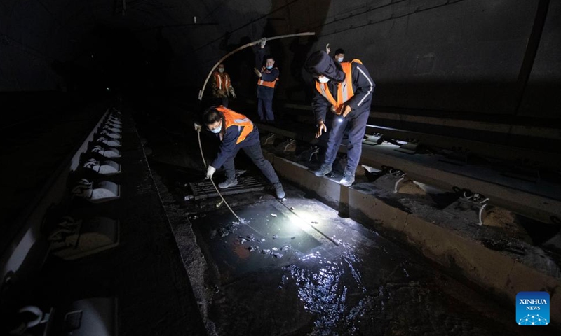 Bridge and tunnel workers dredge the sewerage system of the Wubao Tunnel on the railway linking Taiyuan of north China's Shanxi Province and Zhongwei of northwest China's Ningxia Hui Autonomous Region, Jan. 20, 2022.Photo:Xinhua