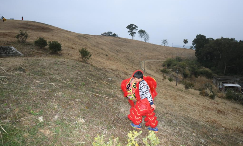 Ji Yukun, 11, a member of a lion dance team, goes for a training at Qiantong ancient town in Ninghai County, east China's Zhejiang Province, Jan. 20, 2022.Photo:Xinhua