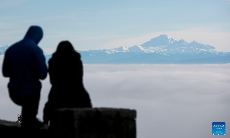 Residents look in the direction of the fog-covered city of Vancouver from Cypress Mountain in Vancouver, Canada, on Jan. 23, 2022.Photo:Xinhua