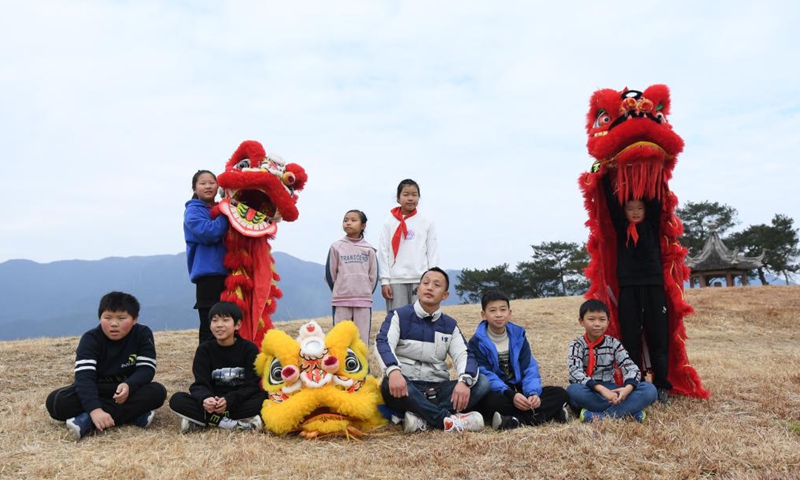 Tong Panfeng (C front) poses for a group photo with some members of a lion dance team near Qiantong ancient town in Ninghai County, east China's Zhejiang Province, Jan. 21, 2022.Photo:Xinhua