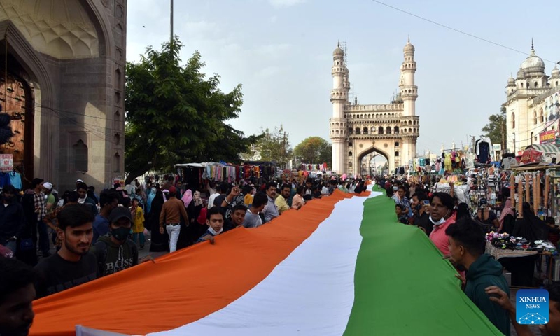 People hold a 300-meter long Indian national flag on the eve of India's 73rd Republic Day celebrations in the old city of Hyderabad, India, on Jan. 25, 2022. (Str/Xinhua)