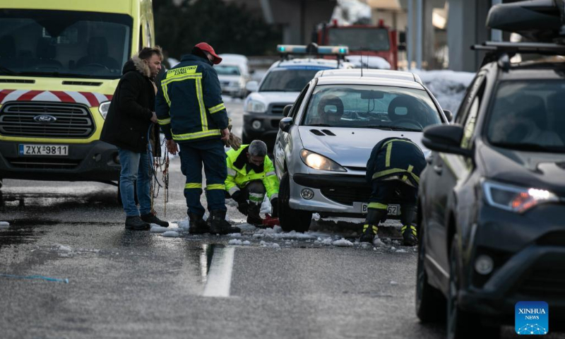 Firefighters work to remove a stranded vehicle in Athens, Greece, on Jan. 26, 2022, two days after heavy snowfall hit the city. Photo:xinhua