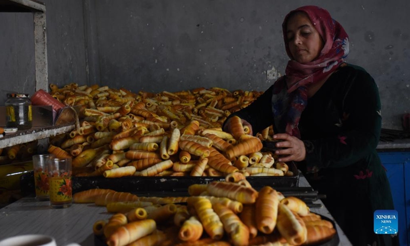 A woman works at a confectionery factory in Mazar-i-Sharif, capital of Balkh province, Afghanistan, Jan. 18, 2022. Contrary to alleged reports of women being confined to home under Afghanistan's Taliban administration, nearly a dozen women and girls are seen hard at work in a confectionery shop here. TO TO WITH Feature: Afghan woman make their own sweet living in Mazar-i-Sharif(Photo: Xinhua)