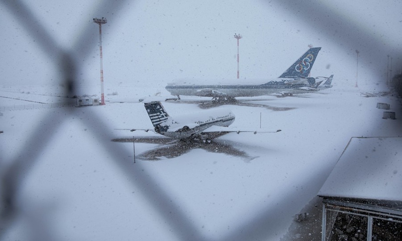 Photo taken on Jan. 24, 2022 shows airplanes at a former airport during heavy snowfall on Athens' southern coast, Greece.(Photo: Xinhua)