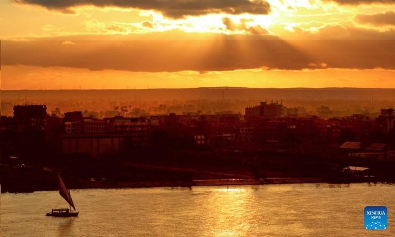 A boat sails on the Nile reddened by flaming clouds at sunset in Cairo, Egypt, on Jan. 26, 2022. Photo:Xinhua