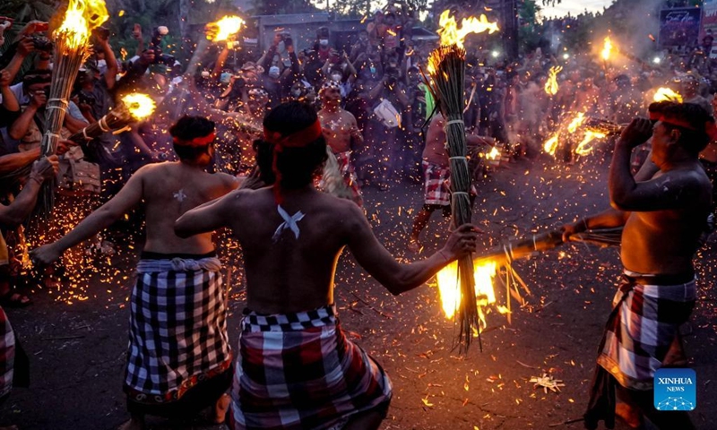 People participate in a fire war ceremony, locally called Siat Geni, at Duda Village in Bali, Indonesia, Jan. 31, 2022. (Photo by Bisinglasi/Xinhua)