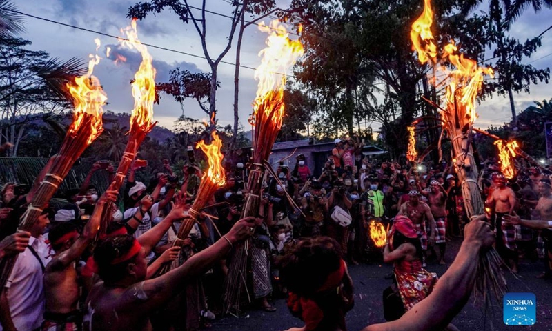 People participate in a fire war ceremony, locally called Siat Geni, at Duda Village in Bali, Indonesia, Jan. 31, 2022. (Photo by Bisinglasi/Xinhua)