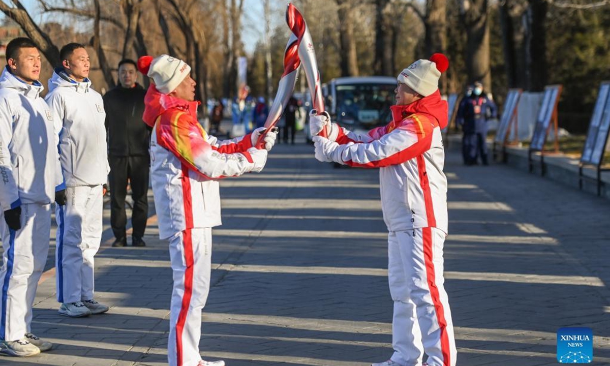 Torch bearers Zhu Dongyun (R) and Li Su attend the Beijing 2022 Olympic Torch Relay at the Summer Palace in Beijing, capital of China, Feb. 4, 2022. (Xinhua/Chen Yehua)