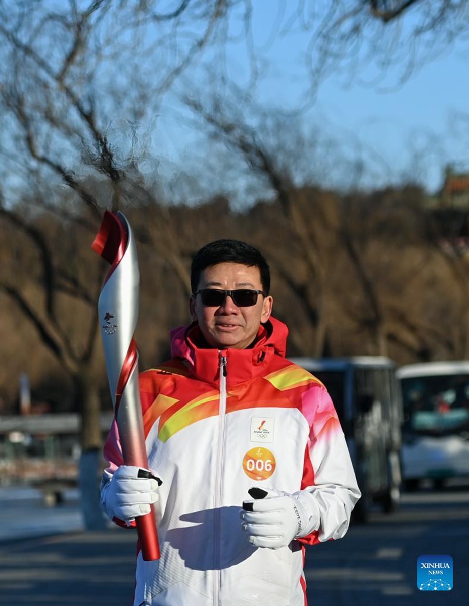 Torch bearer Chen Zhongwei runs with the torch during the Beijing 2022 Olympic Torch Relay at the Summer Palace in Beijing, capital of China, Feb. 4, 2022. (Xinhua/Chen Yehua)