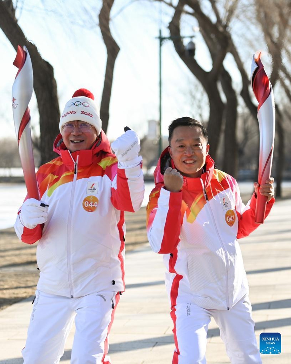 Torch bearers Shang Xiping (L) and Dang Jian attend the Beijing 2022 Olympic Torch Relay at the Summer Palace in Beijing, capital of China, Feb. 4, 2022. (Xinhua/Chen Yehua)