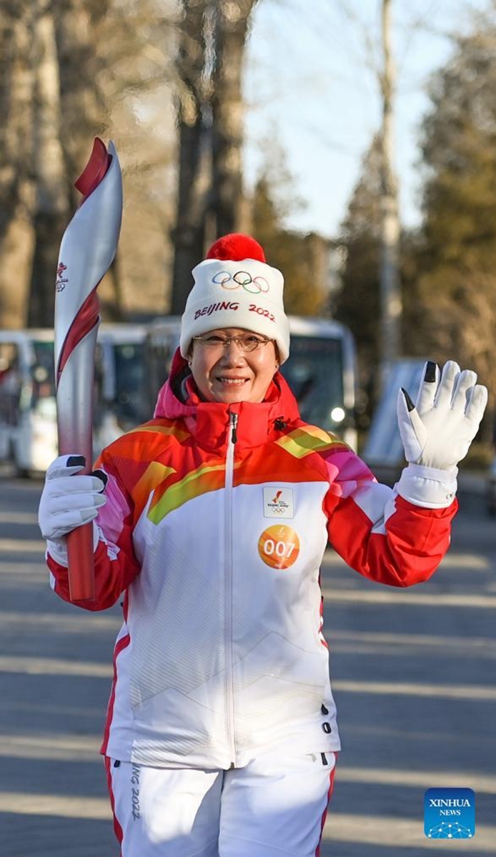 Torch bearer Zhu Dongyun runs with the torch during the Beijing 2022 Olympic Torch Relay at the Summer Palace in Beijing, capital of China, Feb. 4, 2022. (Xinhua/Chen Yehua)