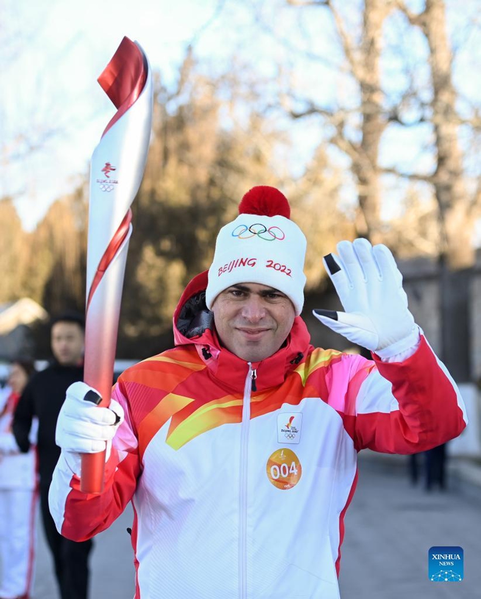 Torch bearer Rodrigo d'Andrea Garcia runs with the torch during the Beijing 2022 Olympic Torch Relay at the Summer Palace in Beijing, capital of China, Feb. 4, 2022. (Xinhua/Chen Yehua)