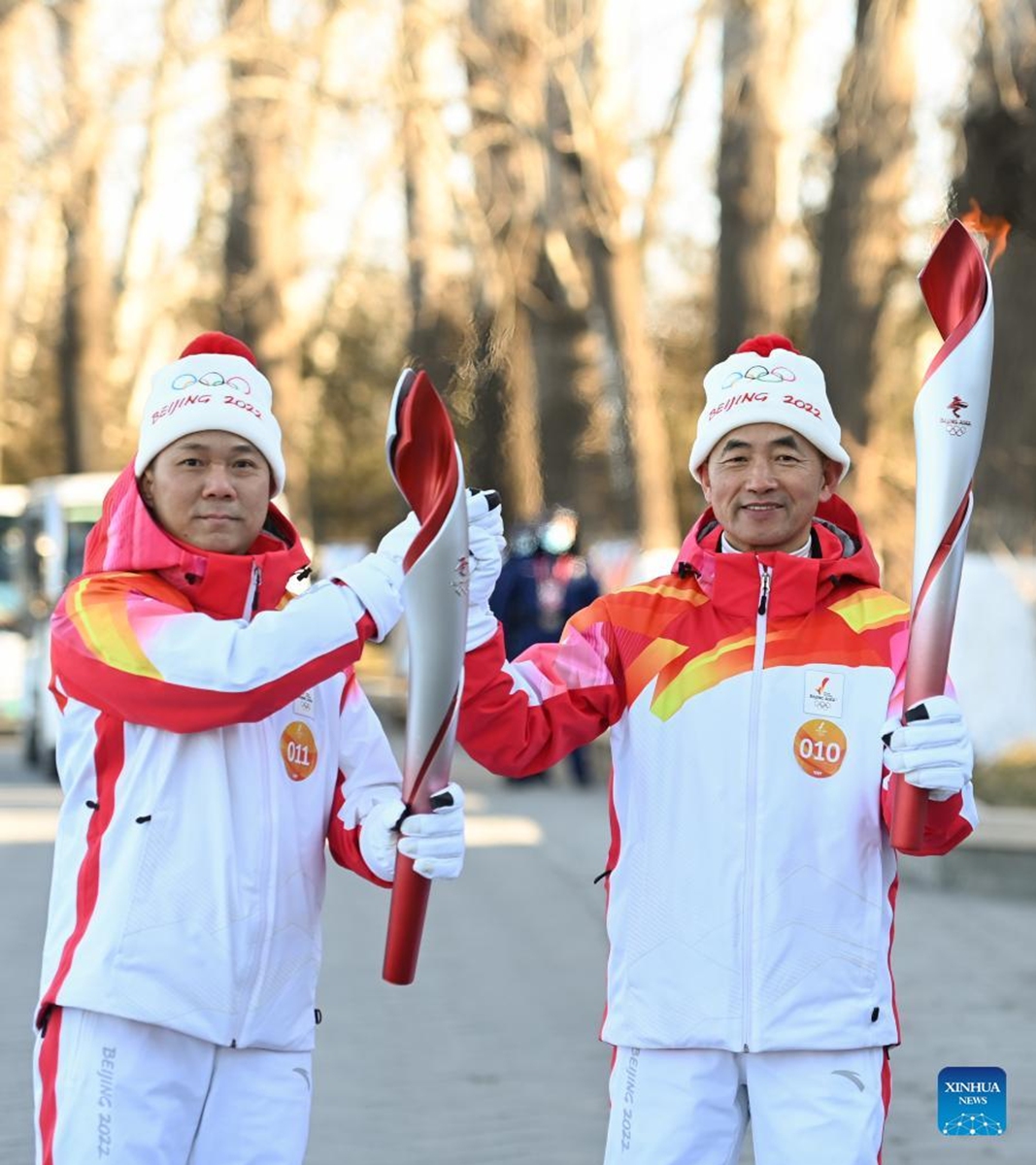 Torch bearers Li Jinsheng (L) and Su Weiqing attend the Beijing 2022 Olympic Torch Relay at the Summer Palace in Beijing, capital of China, Feb. 4, 2022. (Xinhua/Chen Yehua)