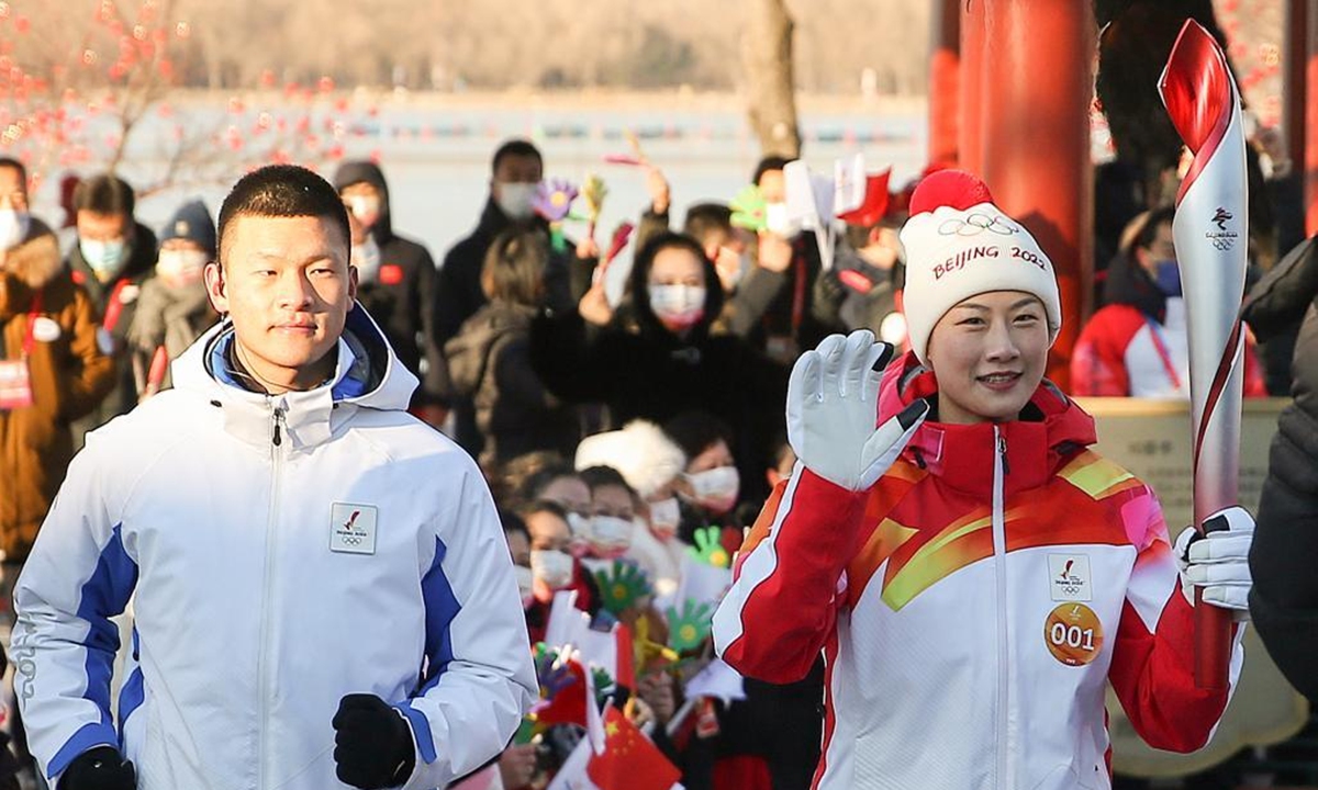 Torch bearer Ding Ning (front R) runs with the torch during the Beijing 2022 Olympic Torch Relay at the Summer Palace in Beijing, capital of China, Feb. 4, 2022. (Xinhua/Jia Haocheng)