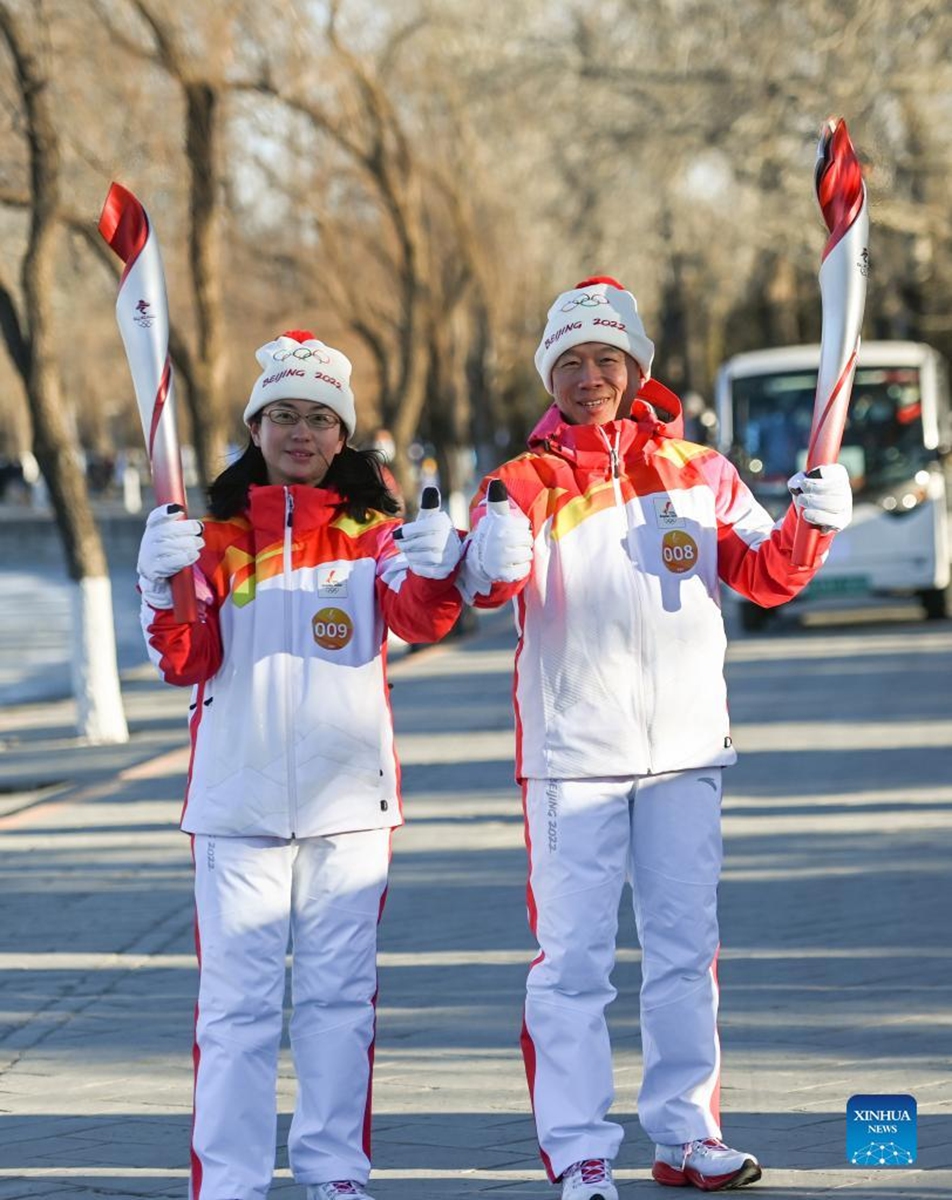 Torch bearer Li Su (R) and Zhu Shuanghong attend the Beijing 2022 Olympic Torch Relay at the Summer Palace in Beijing, capital of China, Feb. 4, 2022. (Xinhua/Chen Yehua)