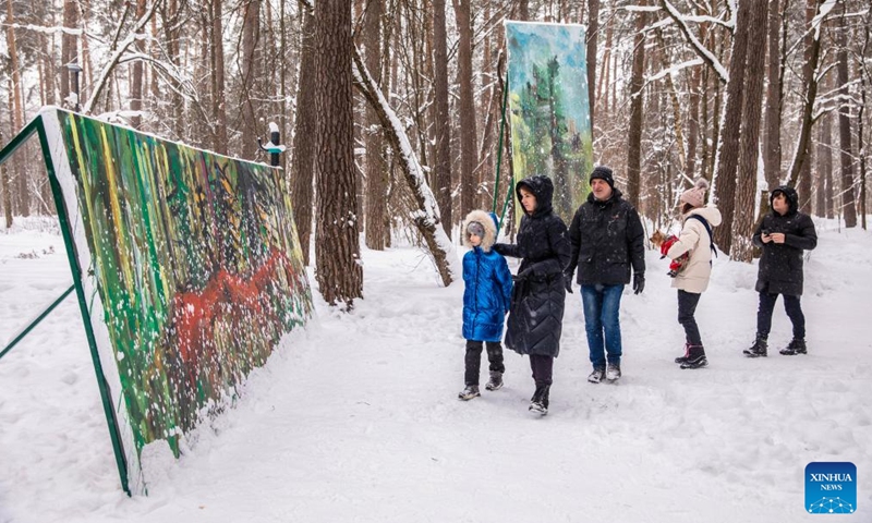 People view paintings at an open-air art exhibition titled White Forest in Malevich Park outside Moscow, Russia, on Feb. 6, 2022.Photo;Xinhua