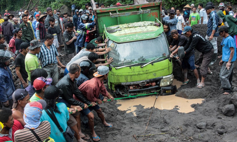 People try to evacuate vehicles trapped in cold lava from Mount Merapi along the Boyong River in Sleman district, Yogyakarta, Indonesia, Feb. 3, 2022.Photo:Xinhua