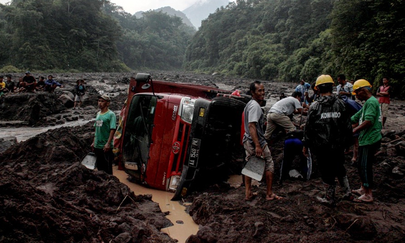 People try to evacuate vehicles trapped in cold lava from Mount Merapi along the Boyong River in Sleman district, Yogyakarta, Indonesia, Feb. 3, 2022.Photo:Xinhua