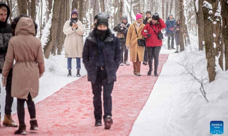 People walk on a 250-meter red carpet at an open-air art exhibition titled White Forest in Malevich Park outside Moscow, Russia, on Feb. 6, 2022.Photo;Xinhua