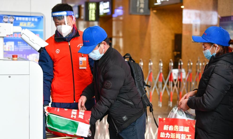 Migrant workers receive security check at Zunyi Station in Zunyi, southwest China's Guizhou Province, Feb. 8, 2022.Photo:Xinhua