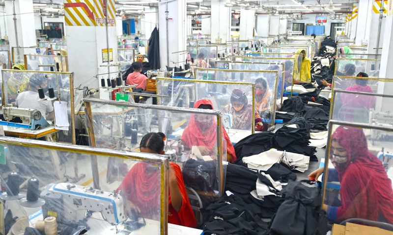 Photo taken on Aug. 23, 2021 shows sewing desks with plastic curtains installed to maintain social distancing for workers at a garment factory in Dhaka, Bangladesh.Photo:Xinhua