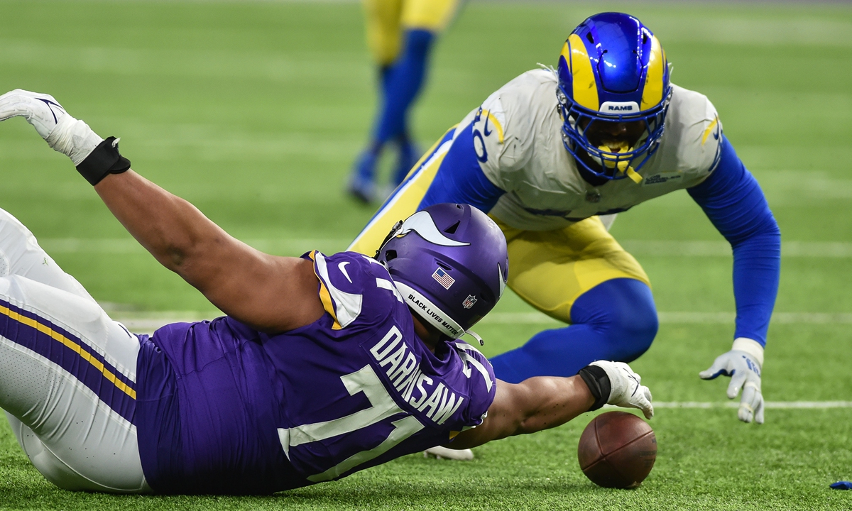 Minnesota Vikings offensive tackle Christian Darrisaw (left) and Los Angeles Rams outside linebacker Von Miller chase a fumble by quarterback Kirk Cousins on December 26, 2021 in Minneapolis. Photo: IC