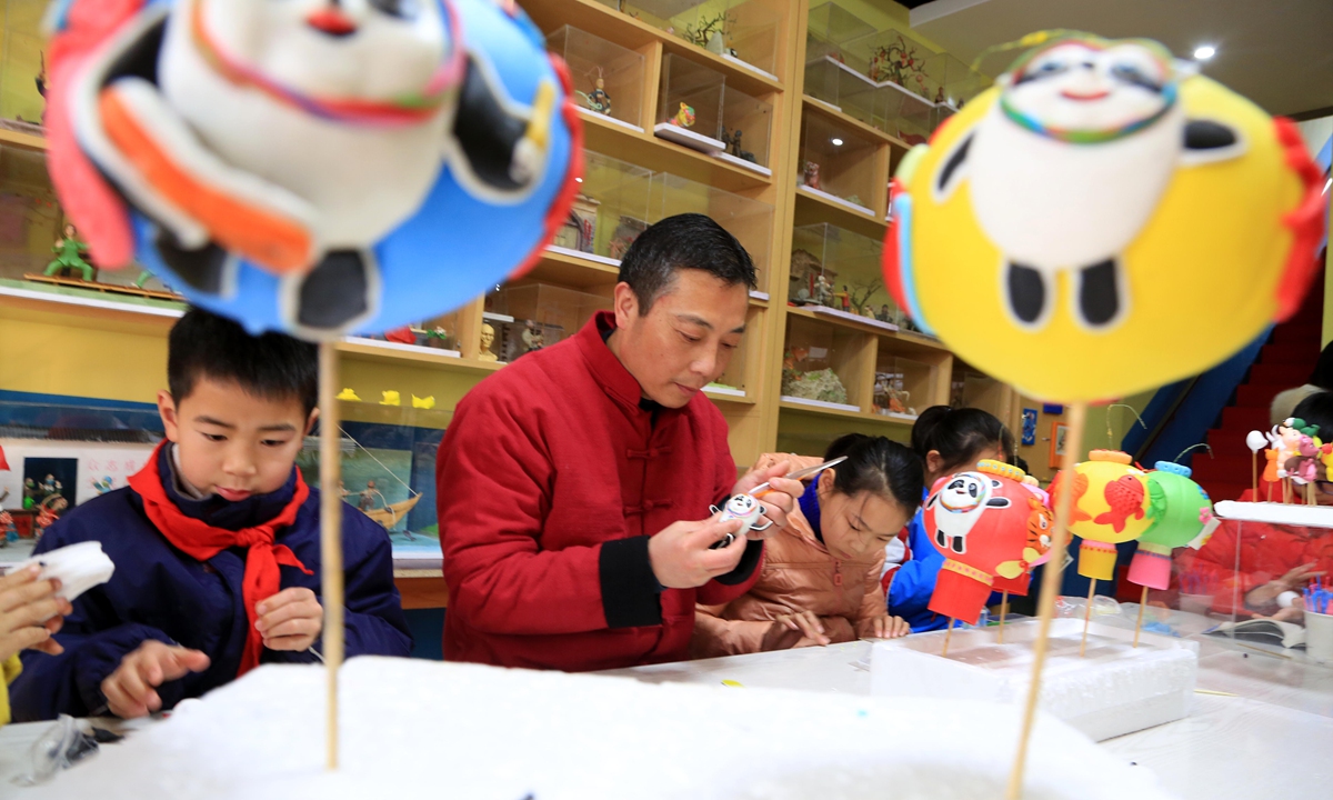 

Children learn to make dough figurines of Beijing 2022 Winter Olympics mascots in the studio of Sun Liandong, inheritor of intangible cultural heritage dough figurines, in Lianyungang, East China's Jiangsu Province on February 13, 2022 to embrace the Lantern Festival which falls on February 15. Photo: IC