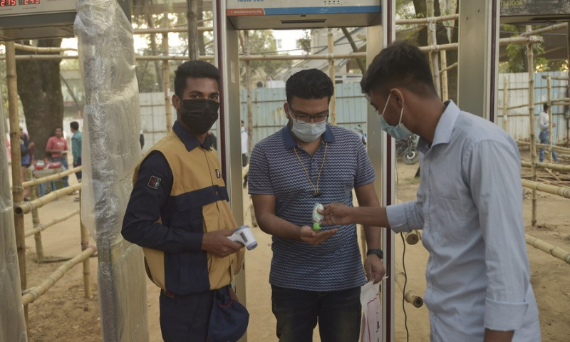 A visitor gets his hands sanitized at the entrance to a book fair in Dhaka, capital of Bangladesh, on Feb. 15, 2022. (Photo: Xinhua)