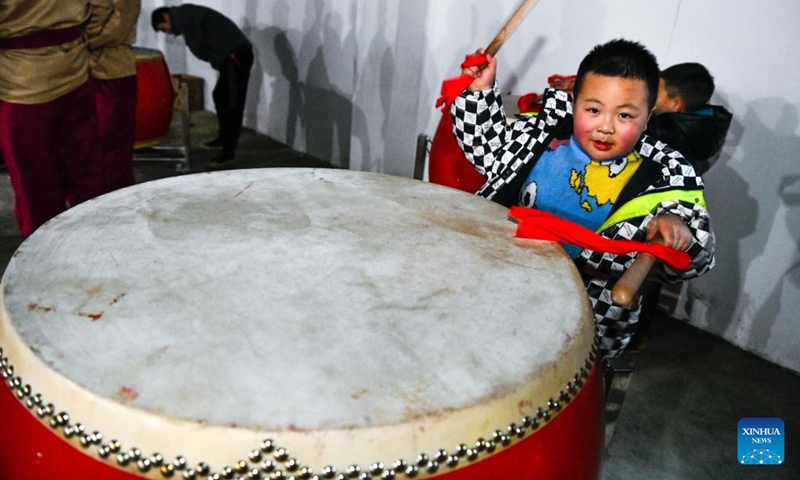 A child plays with a drum in Longshan Township, southwest China's Guizhou Province, Feb. 7, 2022. Deep in the mountains in Longli County, Qiannan Buyi and Miao Autonomous Prefecture, there is a grass-roots troupe performing Taiping Huadengxi, or Taiping lantern opera, in Longli.(Photo: Xinhua)