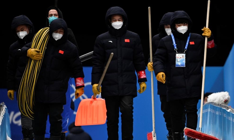 Ice maker Zhu Yongtao (1st R), together with his co-workers, maintains the track at the National Sliding Centre in Yanqing District, Beijing, capital of China, Feb. 15, 2022.Photo：Xinhua
