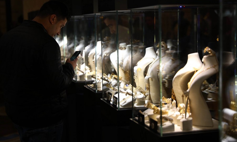 A man takes photos of jewelry during the Nebu expo for gold and jewelry in Cairo, Egypt, on Feb. 20, 2022.(Photo: Xinhua)